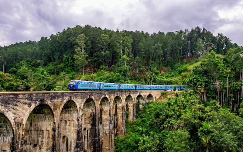 Scenic train crossing the Nine Arches Bridge in Ella